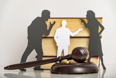 cutouts of divorcing couple and lawyer in front of gavel