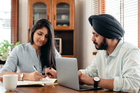 people working on transfer paperwork with laptop