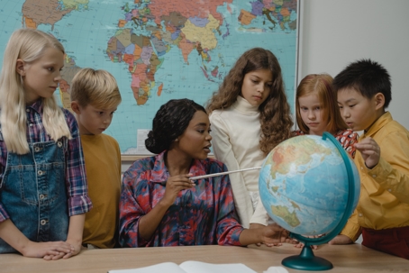 teacher with students and world map