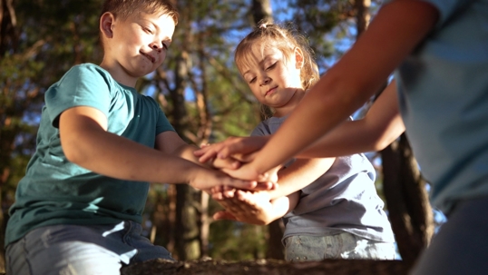 Children placing hands in group